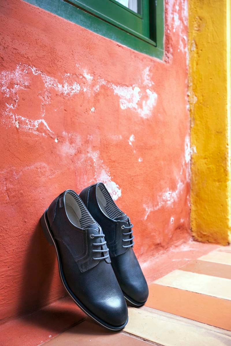 Photograph of some Pikolinos men's shoes leaning against a red wall