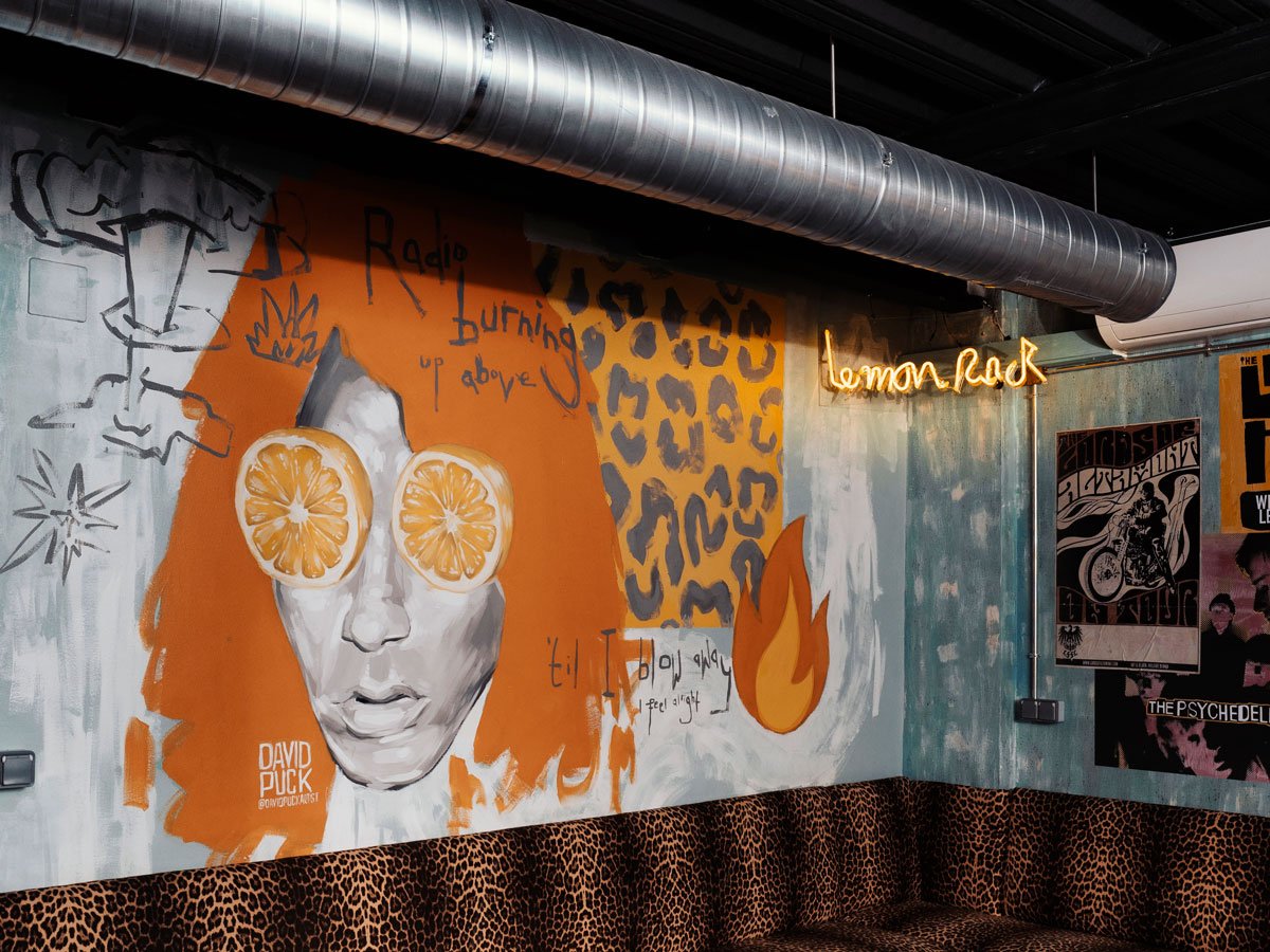 Photograph of one of the rooms of the Lemon Rock Granada bar with tall tables and plants