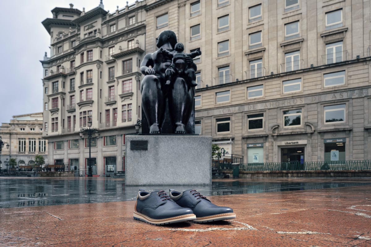 Imagen de un par de zapatos Pikolinos con una escultura al fondo.