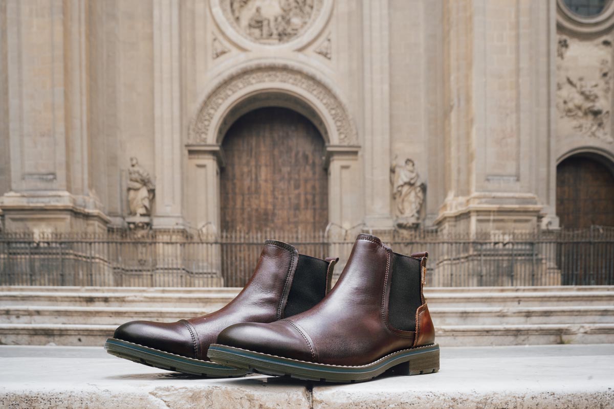 Image of a pair of Pikolinos men's ankle boots in front of Granada Cathedral