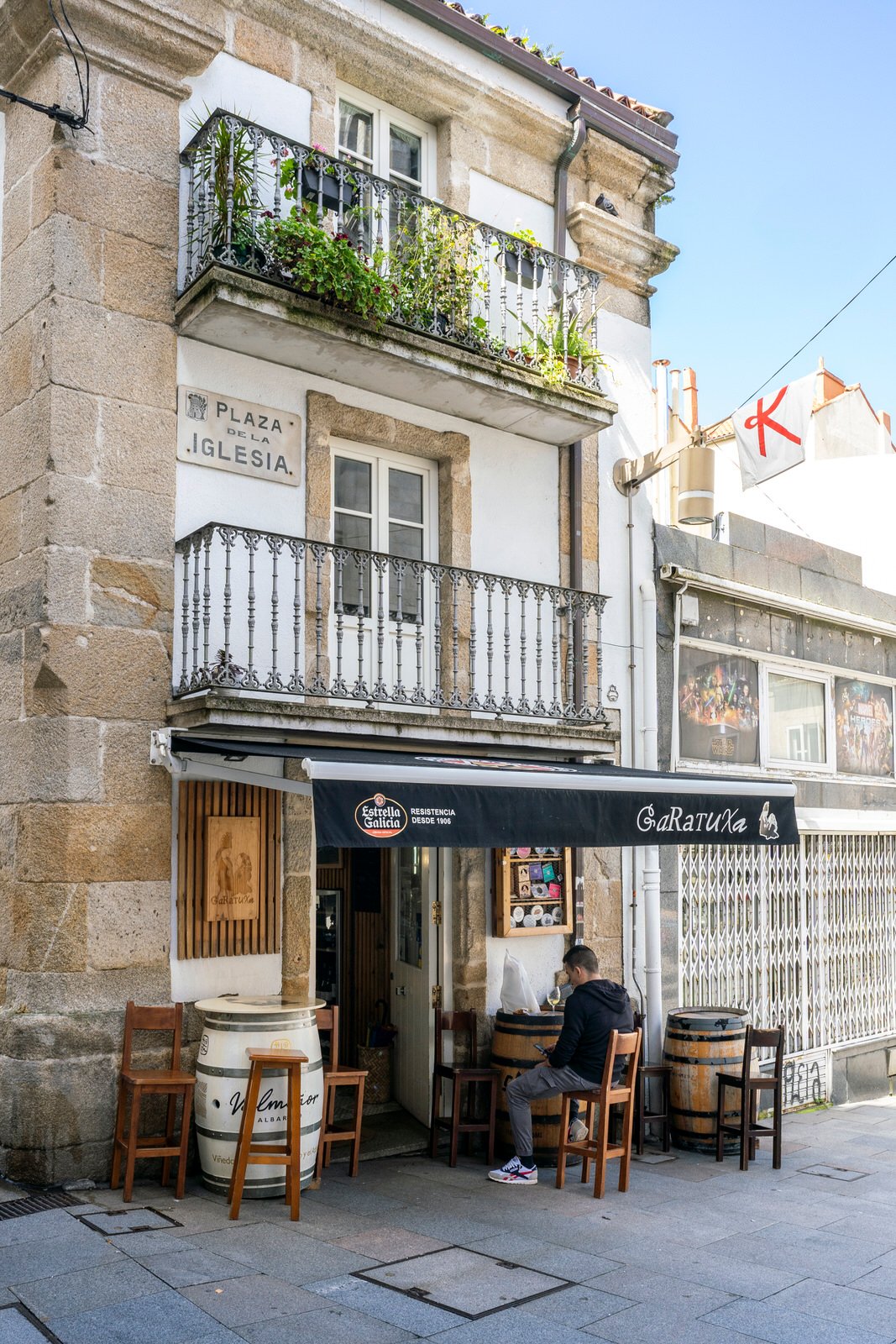 Imagen de la fachada de un edificio histórico, con balcones clásicos y un bar.