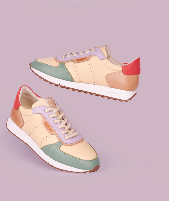 Deportivos de mujer de varios colores sobre un fondo lila