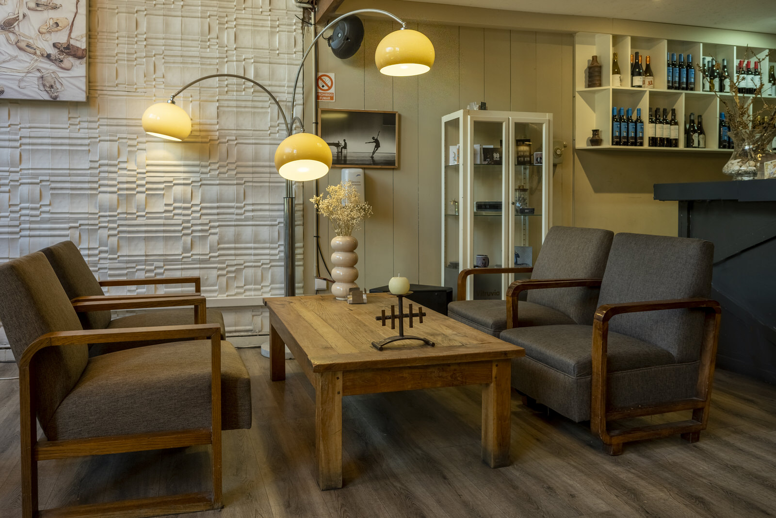 Imagen del interior de la cafetería, con unos sillones y una lámpara de pie