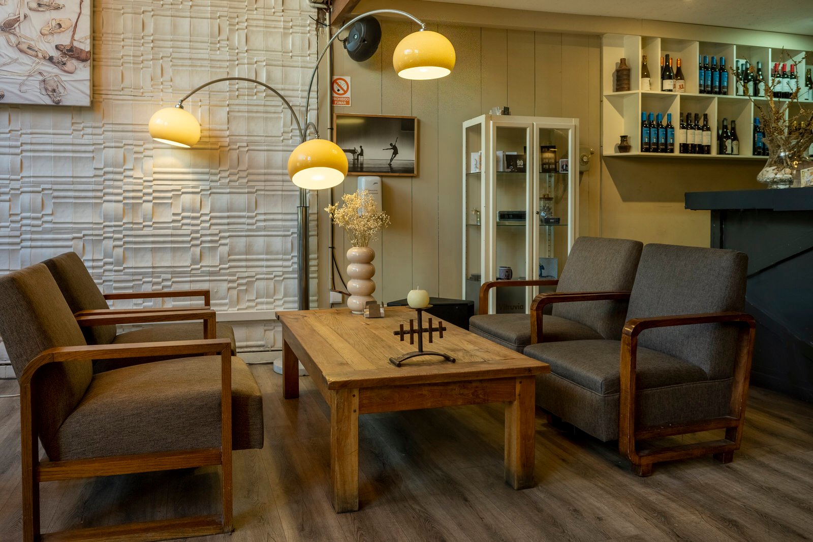 Image of the interior of the cafeteria, with some armchairs and a floor lamp