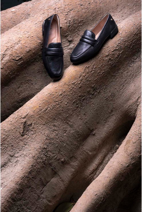 Photograph of black women's loafers on the trunk of a ficus tree