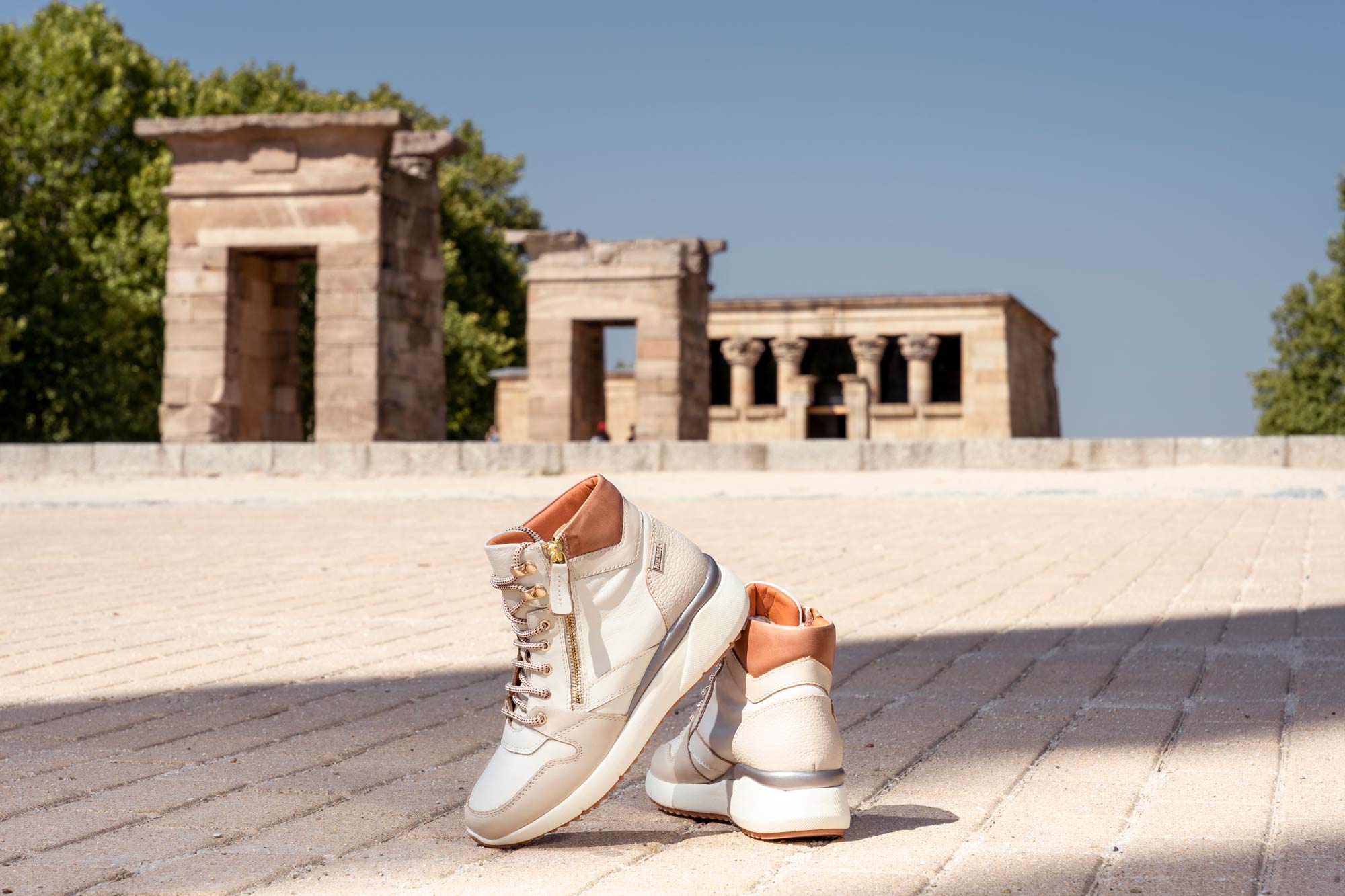 Bild einiger Pikolinos-Schuhe mit dem Seilbahnplakat im Hintergrund.