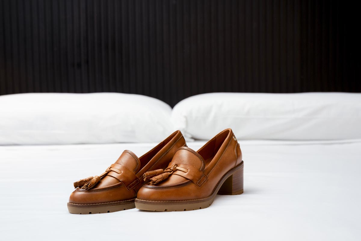 Image of a pair of Pikolinos on a bed.
                        