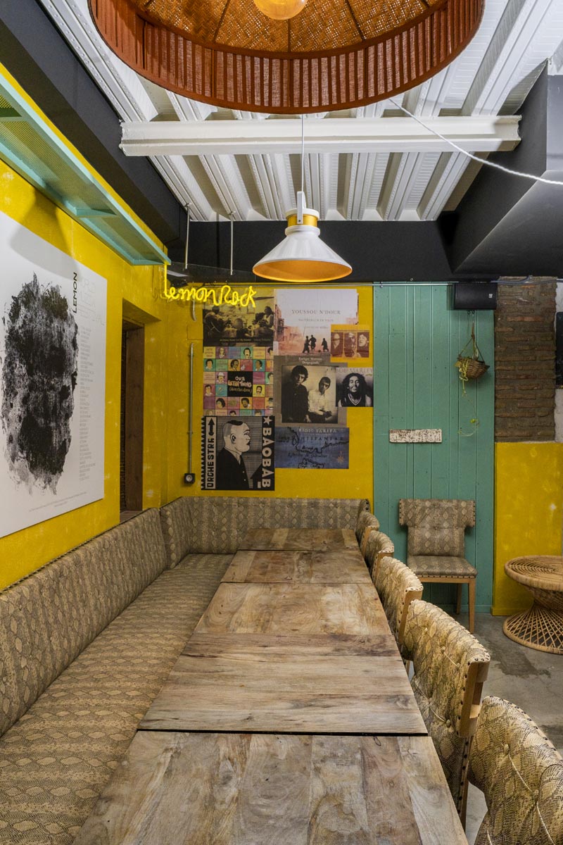 Photograph of one of the rooms of the Lemon Rock Granada bar with a long table and colored walls