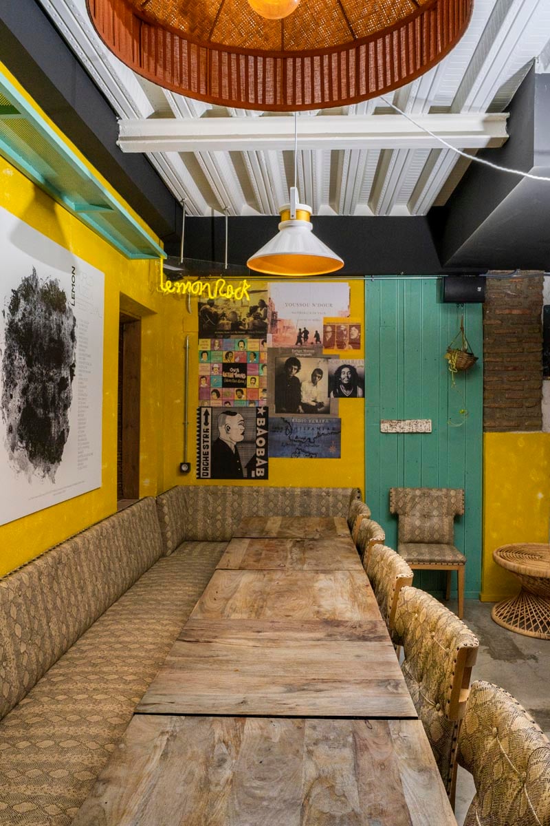 Photograph of one of the rooms of the Lemon Rock Granada bar with a long table and colored walls