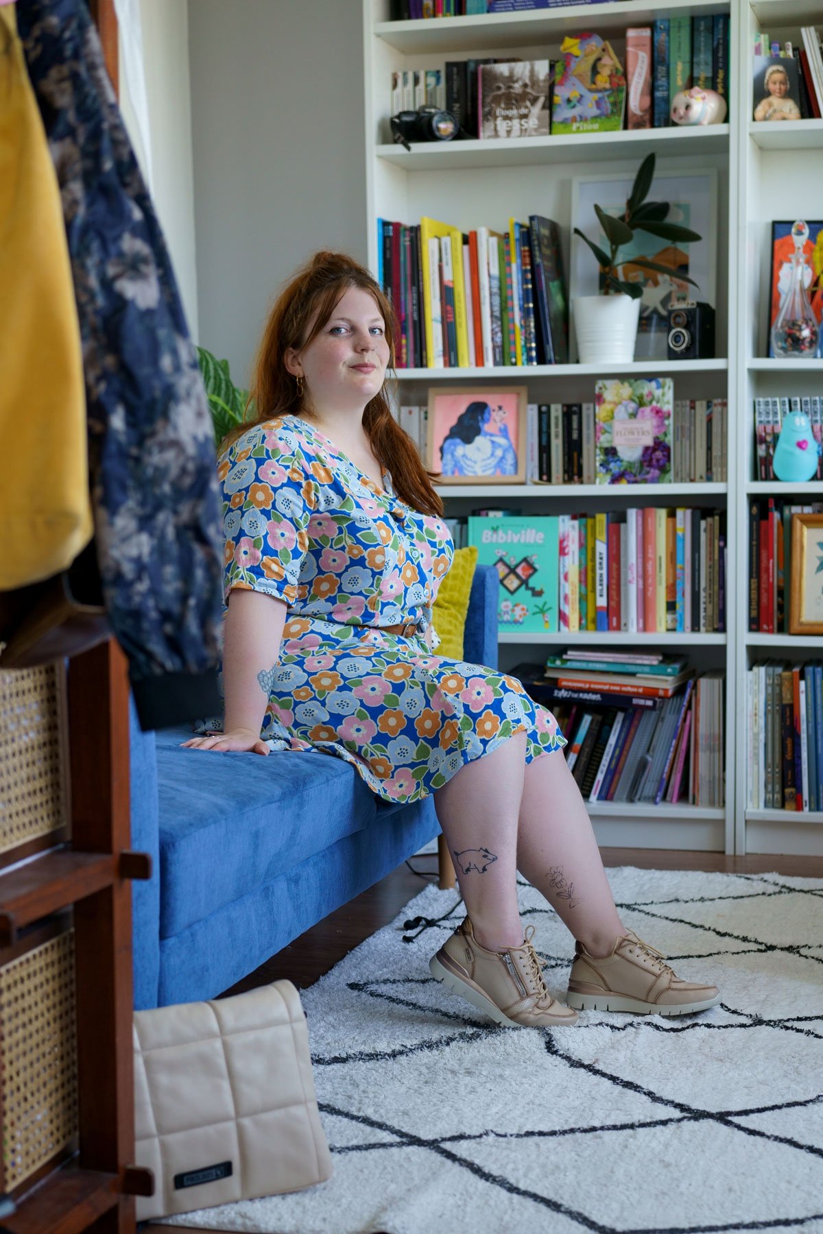 Photograph of Marie sitting on a sofa wearing sneakers and a Pikolinos bag.