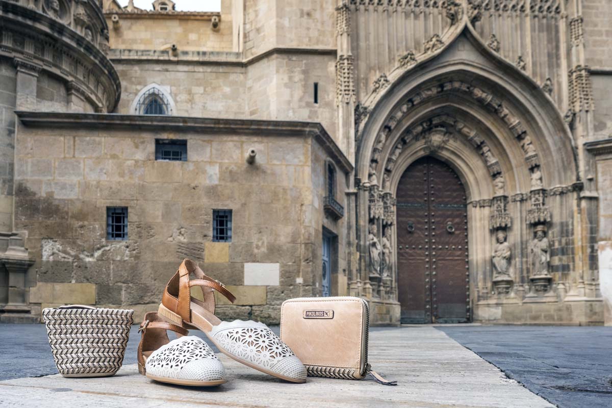 Picture of a Pikolinos handbag, wallet and women's shoes with the cathedral in the background.