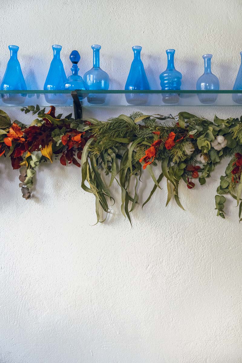 Fotografía de unos jarrones y flores decorando la pared del restaurante Estraperlo
