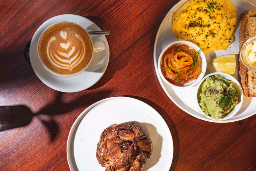 Photograph of a coffee and several plates with food