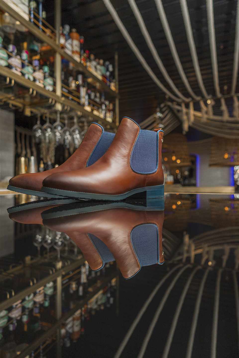 Image of a pair of brown ankle boots on a bar counter.