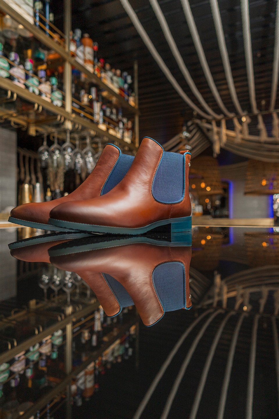 Image of a pair of brown ankle boots on a bar counter.