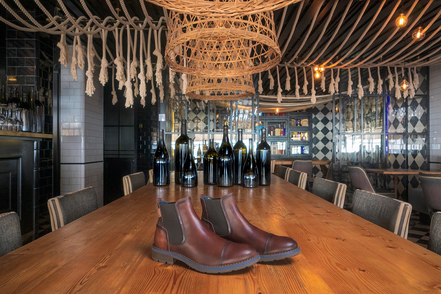 Image of a pair of men's brown ankle boots on a restaurant table.